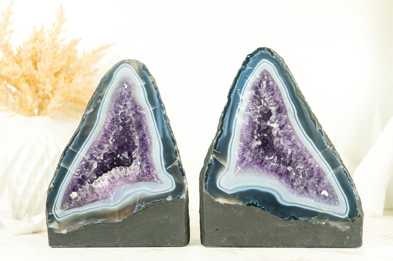 Paar buchgleiche Geoden aus blauem Spitzenachat mit Amethystkristall