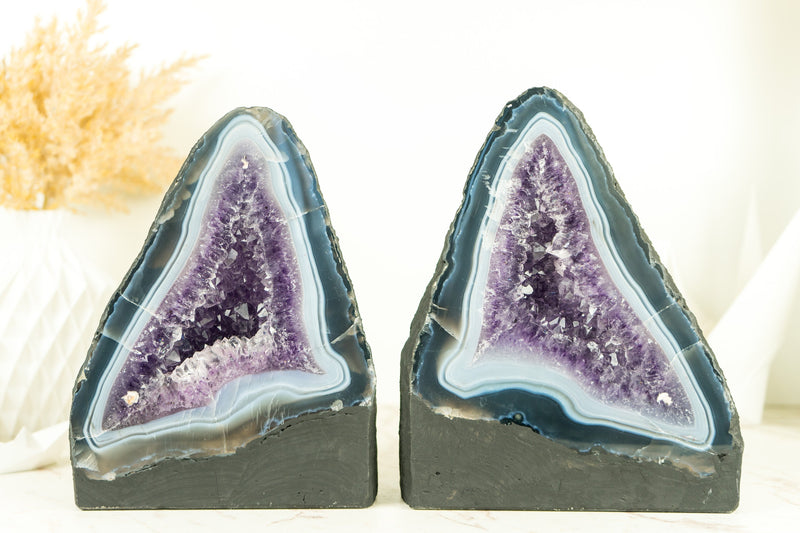 Paar buchgleiche Geoden aus blauem Spitzenachat mit Amethystkristall