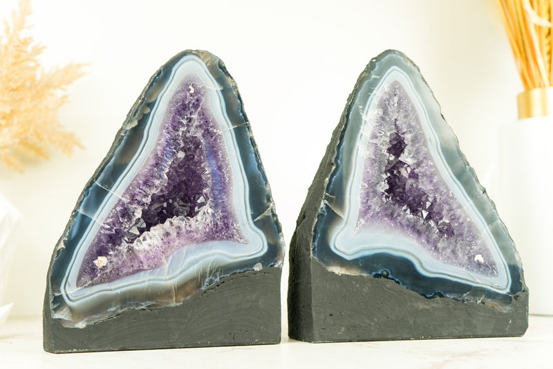Paar buchgleiche Geoden aus blauem Spitzenachat mit Amethystkristall