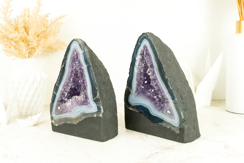 Paar buchgleiche Geoden aus blauem Spitzenachat mit Amethystkristall