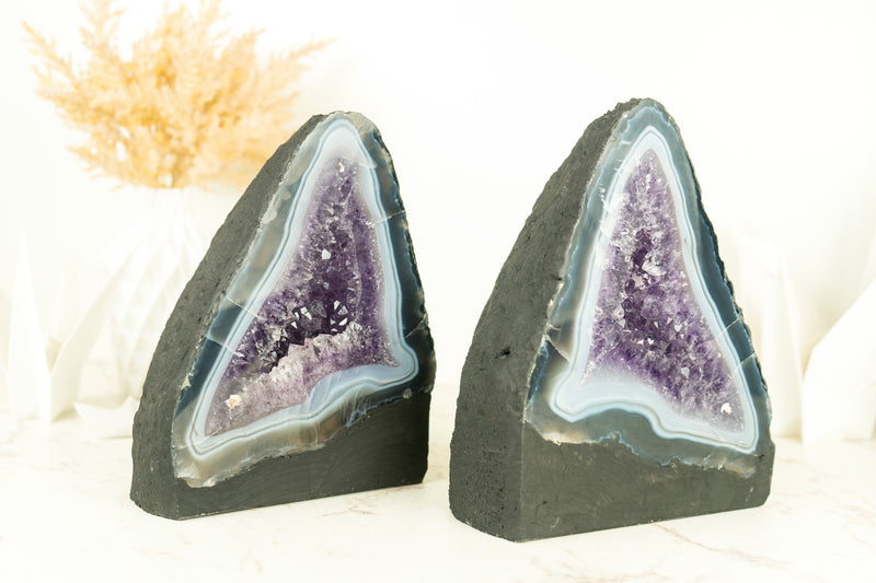 Paar buchgleiche Geoden aus blauem Spitzenachat mit Amethystkristall