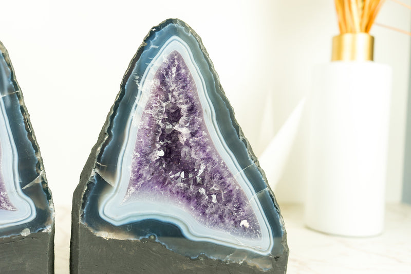 Paar buchgleiche Geoden aus blauem Spitzenachat mit Amethystkristall