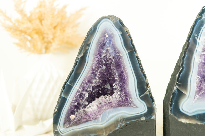 Paar buchgleiche Geoden aus blauem Spitzenachat mit Amethystkristall