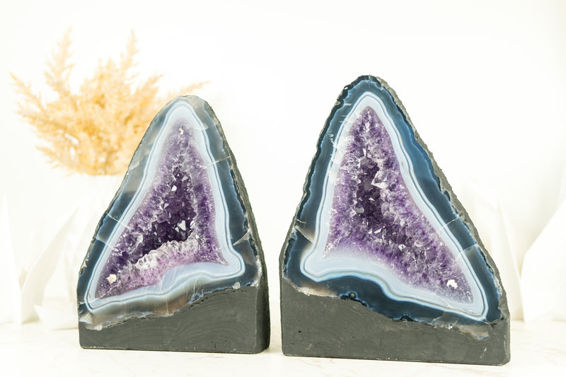 Paar buchgleiche Geoden aus blauem Spitzenachat mit Amethystkristall