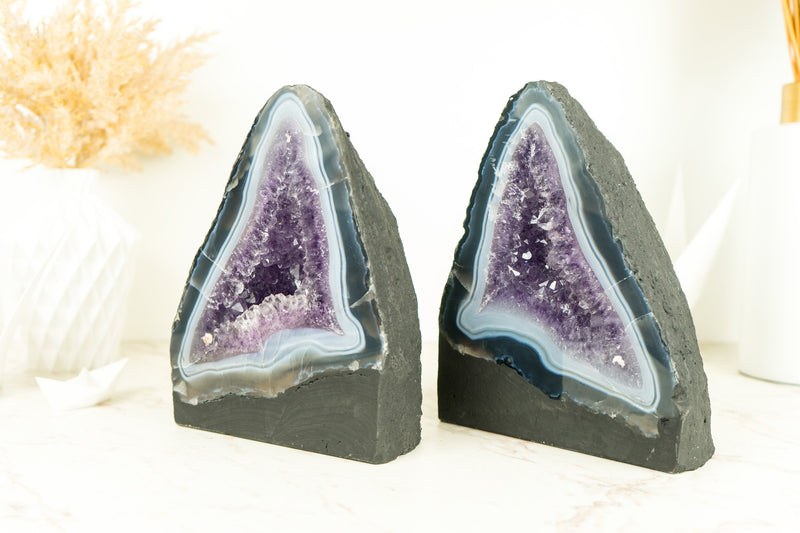 Paar buchgleiche Geoden aus blauem Spitzenachat mit Amethystkristall